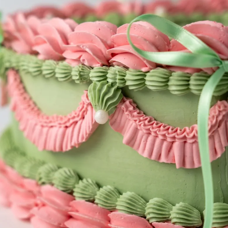 Pastel Corazón Vintage verde con rosetón rosa y lazos verdes de cerca