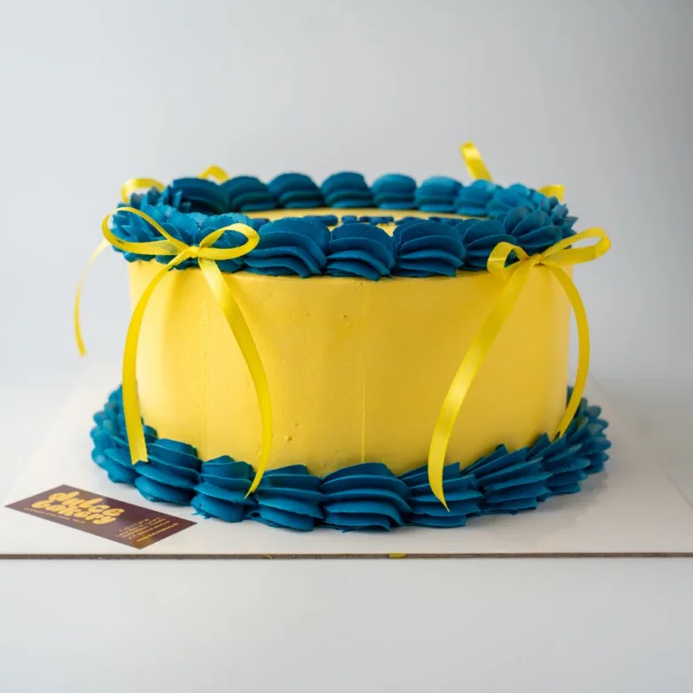 Pastel retro de color amarillo con rosetón y Felicitats en azul