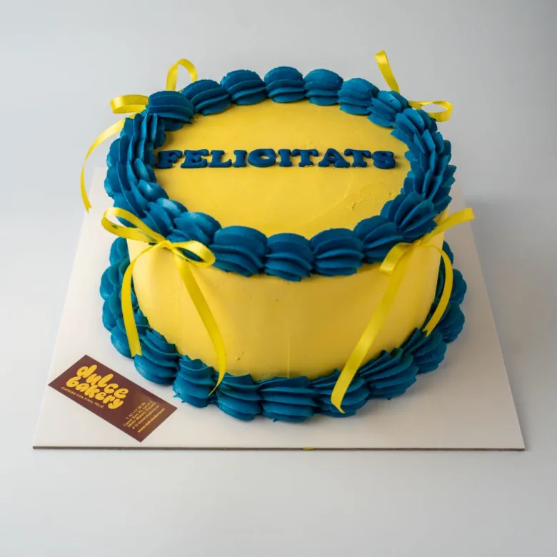 Pastel retro de color amarillo con rosetón y Felicitats en azul