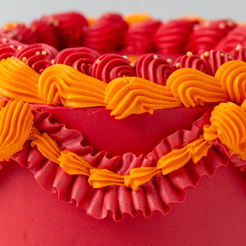 Pastel Vintage rojo con rosetón naranja de cerca