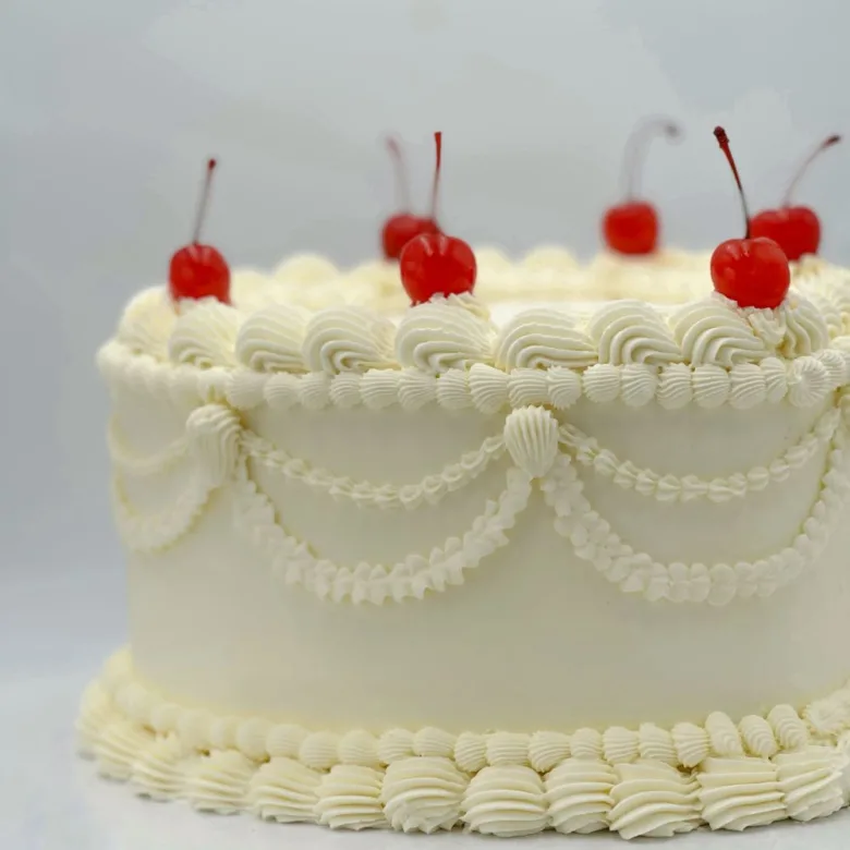 Pastel Corazón Vintage blanco con rosetón y cerezas confitadas